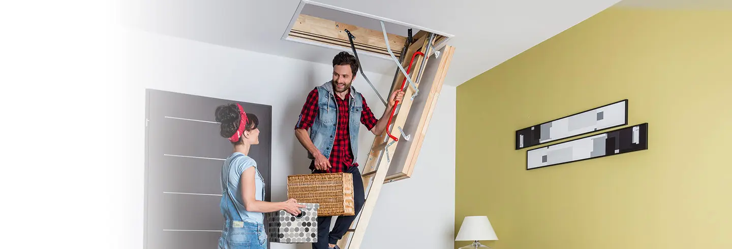 Couple using attic ladder