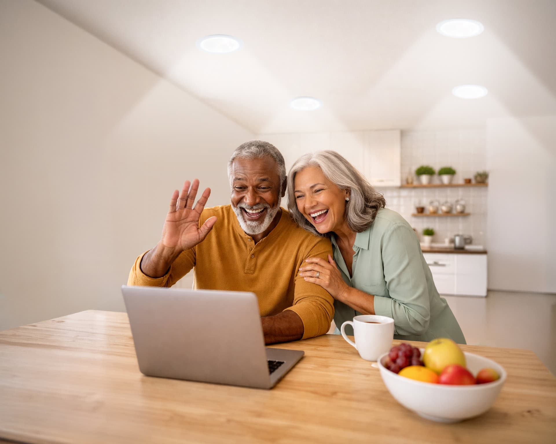 Elderly couple sitting in front of a laptop under natural light